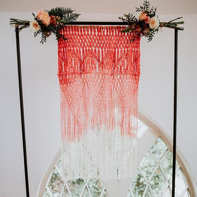 Handmade dip dyed in coral macrame backdrop. Photobackdrop, prop and decor hire | macrame for hire backdrops to hire | Essex
